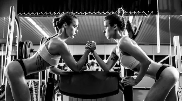 Dos jóvenes mujer fitness, lucha libre de brazos en el gimnasio —  Fotos de Stock