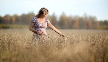 lonely beauty mature woman, walks on the wheat field, horizontal photo clipart