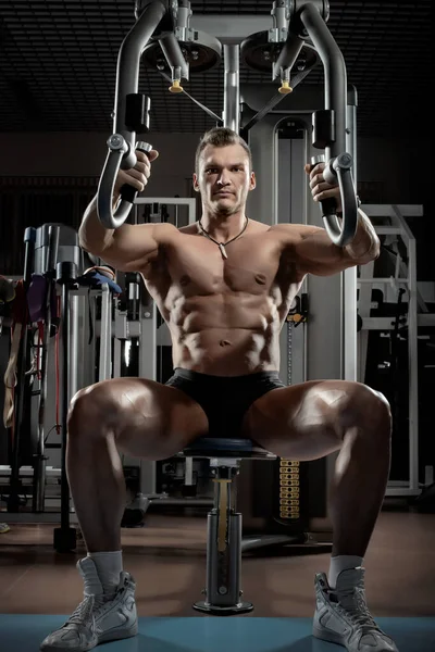 Guy bodybuilder with apparatus Butterfly Machine — Stock Photo, Image