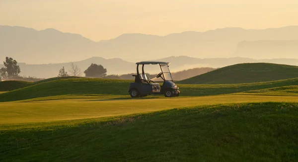 緑のゴルフ場と電気自動車の風景横の写真 — ストック写真