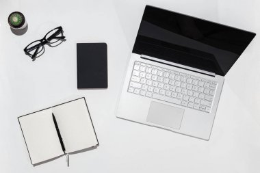 Modern beyaz minimalist Resepsiyon Masa laptop, defter kalem ve gözlük ile. Üstten Görünüm kopya alanı ile. Çalışma Resepsiyon Masa kavramı.