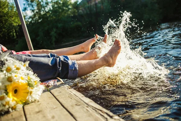 Pareja piernas en el agua salpicaduras — Foto de Stock