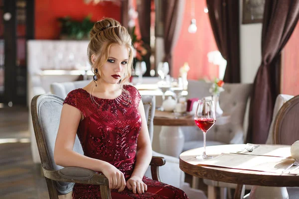 Élégante dame avec un verre de vin rouge au restaurant. Séduisante jeune femme regardant à la caméra — Photo