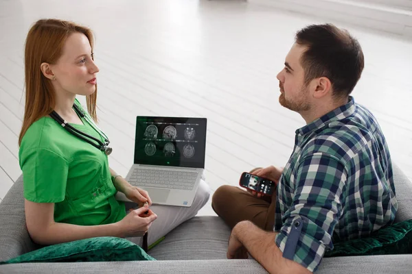 Female doctor and male patient looking at MRI concept healthcare, medical and radiology concept