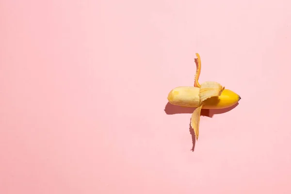 Sweet juicy opened small banana on pink table. Sexual life libido, penis size and potency concept — Stock Photo, Image