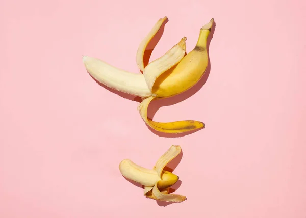 Sweet juicy opened little banana and opened big banana on pink table. Sexual life libido, penis size and potency concept. — Stock Photo, Image