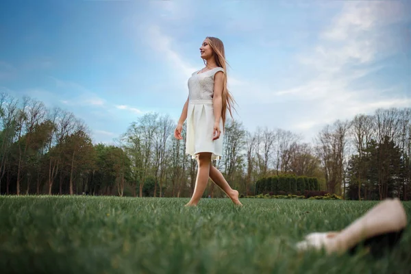 Mulher indo descalça na grama verde. Caminhada noturna para a saúde — Fotografia de Stock