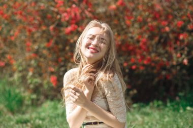 Güneşli bir gün parkta bir güzel bahar gününde çiçek mevsiminde güzel genç kadının.