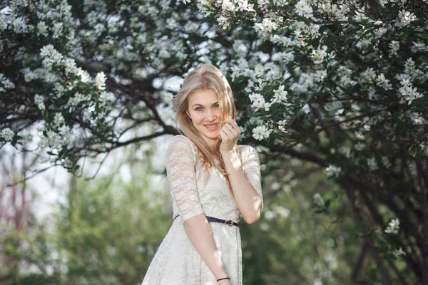 Jeune blonde joyeuse appréciant le jardin de pommiers en fleurs. Printemps florissant, amour, concept de bonheur — Photo