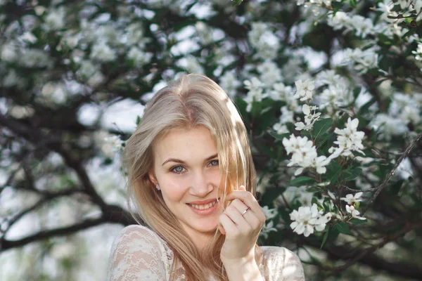 Young cheerful blonde enjoying blossom apple garden. Blooming spring, love, happiness concept — Stock Photo, Image