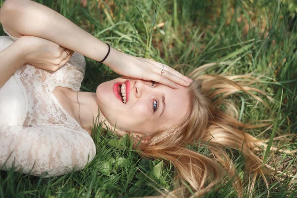 На відкритому повітрі портрет красивої блондинки лежить на зеленій траві — стокове фото