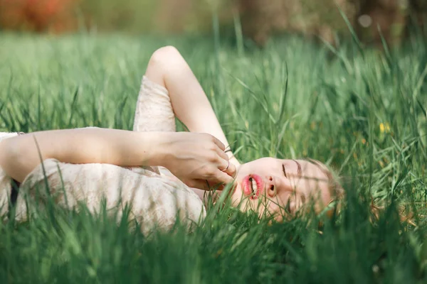 Retrato ao ar livre de bela menina loira deitada na grama verde — Fotografia de Stock