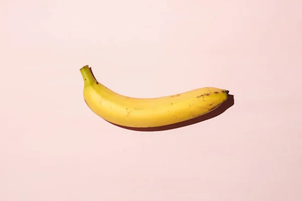 Banana suculenta doce na mesa rosa. Libido vida sexual e conceito de potência. Luz dura . — Fotografia de Stock