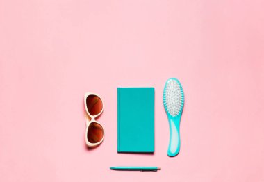 Kadınsı Aksesuar, saç fırçası, gözlük, günlüğü ve pembe kopya alanı üzerinde izole kalem.