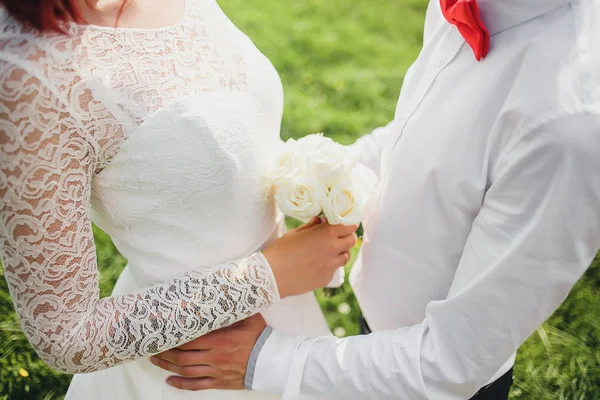 Novia y novio abrazándose sensualmente con ramo de boda en las manos — Foto de Stock