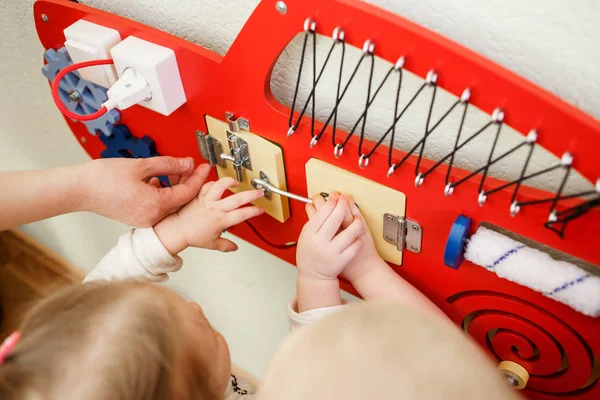 Niedliche Kleinkinder spielen im Kindergarten mit emsigen Brettern — Stockfoto