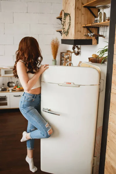 Kot açılış Retro buzdolabı kapı ve buzdolabına bakarak ince kız