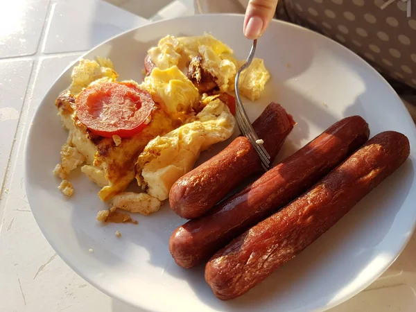 Omelet met volkoren brood en gegrilde worsten. Heerlijk ontbijt. Morning fastfood in het zonlicht — Stockfoto