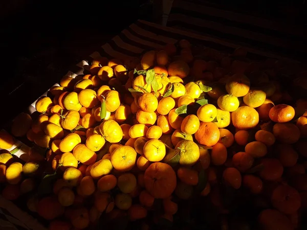 在强烈的阳光下，东部街道上的集市上有一堆橘红色的橘红色的橘子 — 图库照片