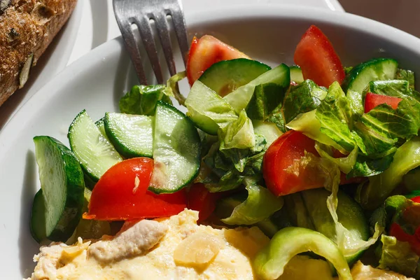 Gezond ontbijt op balkon in zonnig balkon. Volkoren brood met pompoenpitten en omelet. Salade van verse komkommers en tomaten. Direct zonlicht — Stockfoto