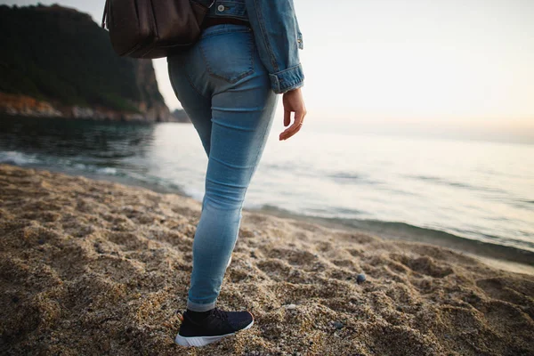 Mujer casada con ropa de mezclilla de pie en la costa del mar. Primer plano de la mano femenina con anillo de oro. Concepto de relación, mental, psicológica y de moda — Foto de Stock