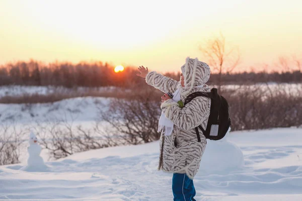 An elderly woman rejoices in the sun in the winter forest. Woman points her hand at the sun on the winter solstice — Stock Photo, Image