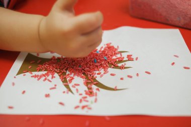 Çocuklar anaokulunda duyusal bir çöp kutusuyla eğitim oyunları oynuyorlar.