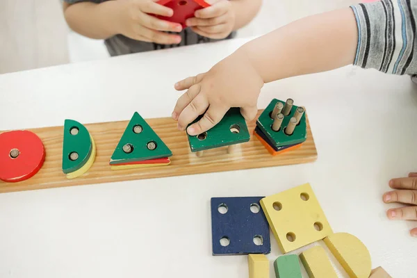 Niños reuniendo bloques de construcción en el jardín de infantes. Juegos educativos y juguetes. De cerca. — Foto de Stock