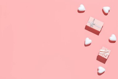 Pembe hediye kutuları ve pembe arka planda beyaz dekoratif kalpler. Düz kompozisyon. Romantik, Sevgililer Günü konsepti