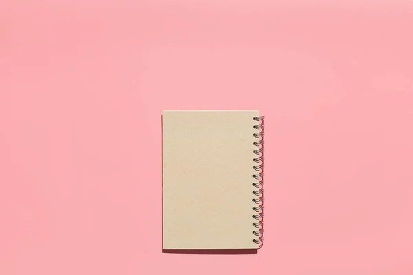 Бледный блокнот на розовом фоне. Плоская композиция. Женское рабочее пространство — стоковое фото
