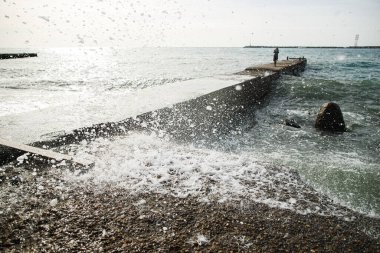 Bahar fırtınalı denizi. Beton iskelede dalgalar dövüyor