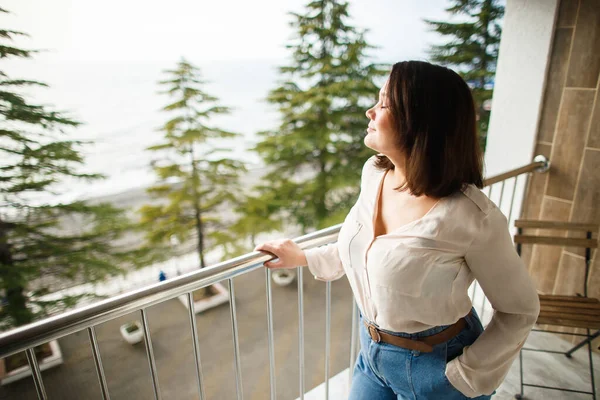 Beautiful girl enjoys the sound of the surf on the balcony of the hotel — 图库照片