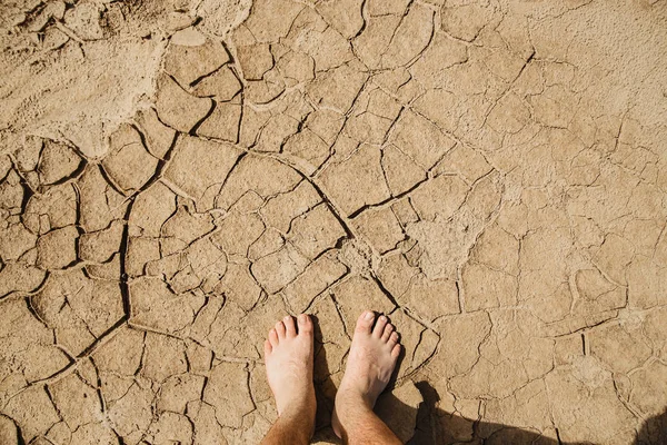 Füße auf rissigem Boden. Das Konzept von Hitze, Dürre, Urlaub — Stockfoto