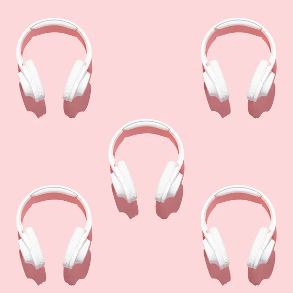 Patrón auriculares blancos en la moderna mesa de color rosa pálido vista superior plana laico. Espacio libre para texto y contenido de diseño creativo —  Fotos de Stock