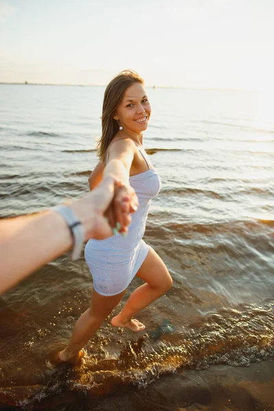 Игривая сексуальная женщина развлекается со мной своим другом-мужчиной на пляже на закате. Веселая молодая женщина с идеальной формой в сексуальном платье на свиданиях — стоковое фото