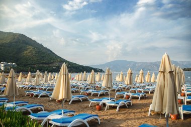 Kumsalda boş şemsiyeler ve plaj sandalyeleri. Marmaris, Turkey. Mantığın başlangıcı..