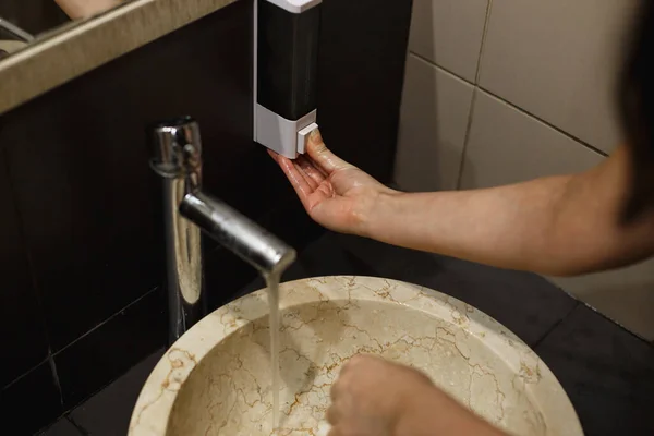공공 장소 화장실에서 비누로 손을 씻는 여자. 병원성 바이러스와 세균에 대한 주의 깊이 손을 씻음 — 스톡 사진