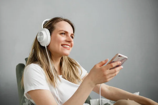 Nikmati musiknya. Wanita muda bahagia menyenangkan musik di headphone putih. — Stok Foto