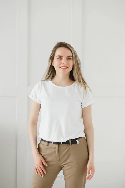 Atractiva mujer caucásica en camiseta blanca y pantalones beige —  Fotos de Stock
