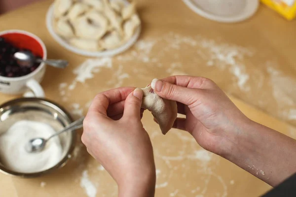 Koken zelfgemaakte dumplings met bosbes, vrouwelijke handen beeldhouwen dumpling closeup — Stockfoto