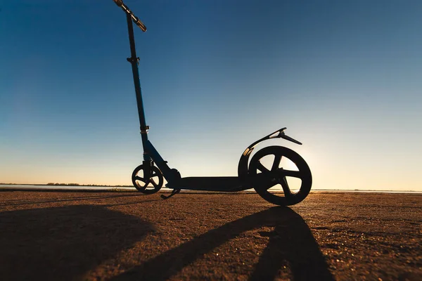 Patada scooter en pista de asfalto, bajo la luz del sol en el soleado día de verano . — Foto de Stock