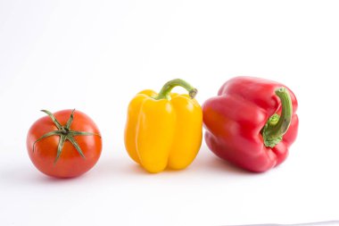 Beyaz bir arka plan üzerinde taze sebze. Sarı biber, kırmızı biber ve domates beyaz bir arka plan üzerinde
