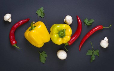 Mantar siyah bir zemin üzerine kırmızı biber. Diyet yiyecek. Sebze siyah bir arka plan. Masanın üzerinde mantar ile acı biber.