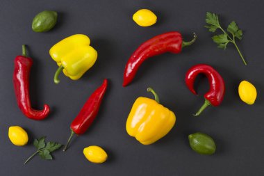 Siyah bir arka plan üzerinde kırmızı ve sarı biber. Diyet yiyecek. Sebze siyah bir arka plan. Masada biber.