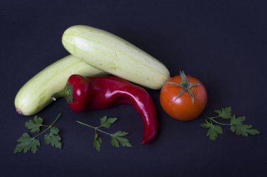 Kabak domates ve kırmızı biber siyah arka plan üzerine. Karanlık bir arka plan üzerinde farklı sebze kompozisyon.