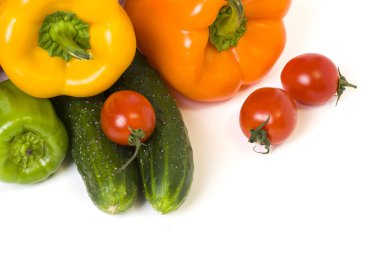 Kırmızı Sarı ve turuncu biber domates üzerinde beyaz bir arka plan ile. Salatalık kompozisyon beyaz bir arka plan üzerinde renkli biber ile