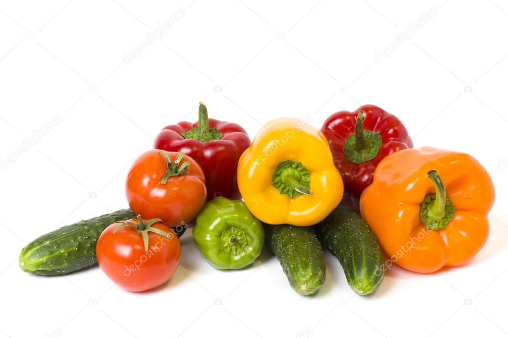 Red yellow and orange peppers with tomatoes on a white background. Cucumbers with colorful peppers in composition on a white background