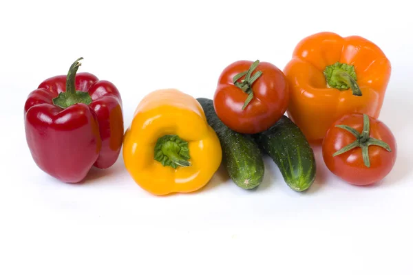Rote gelbe und orangefarbene Paprika mit Tomaten auf weißem Hintergrund — Stockfoto