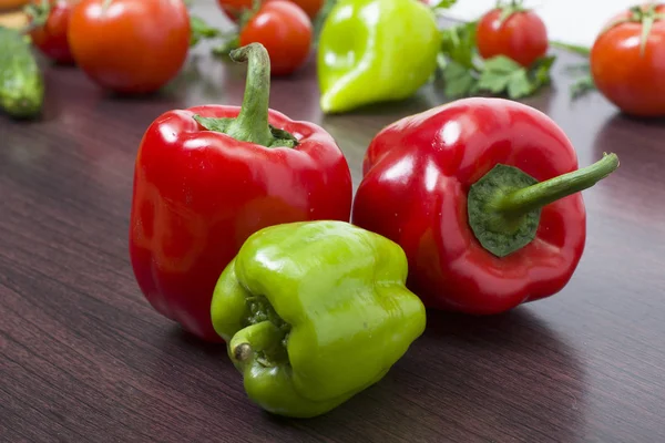 Yeşil ve kırmızı biber domates bir arka plan üzerinde. İki kırmızı — Stok fotoğraf