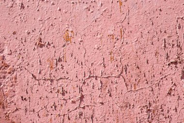 Çatlak ve lekeli eski pembe duvar.